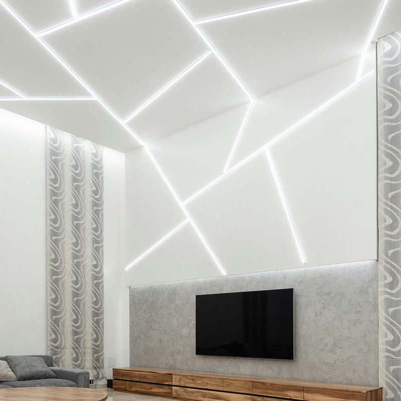 White ceiling with multiple angled LED strips, creating a dynamic, futuristic pattern above a TV area.