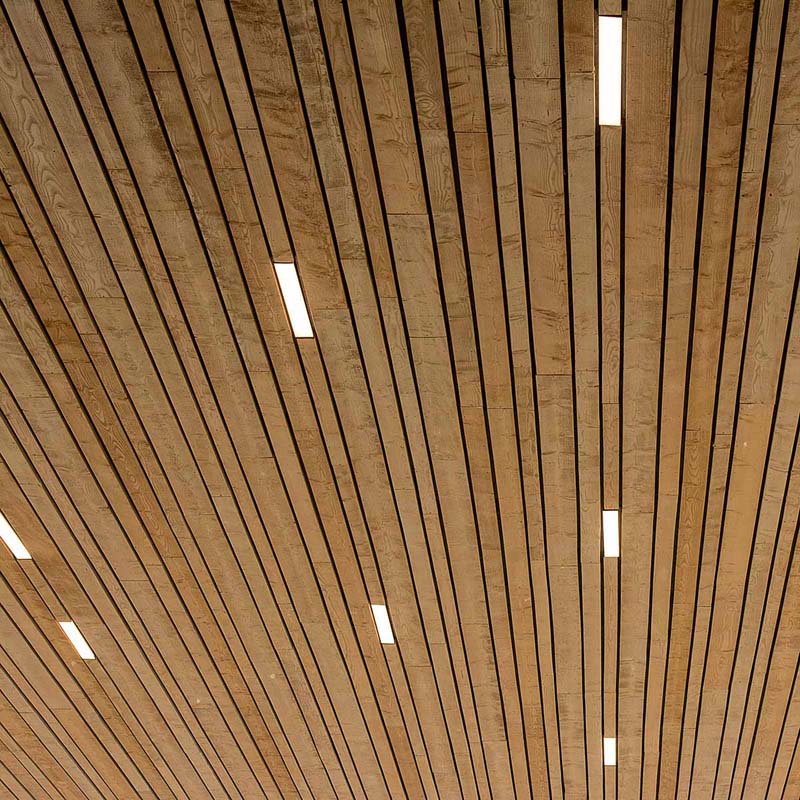 A ceiling composed of parallel wooden slats with slim LED light channels running between them.
