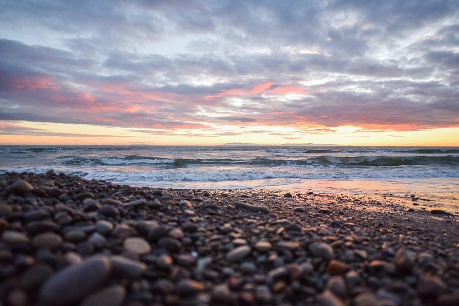 Multicolored sunrise of a pebbled beach. 