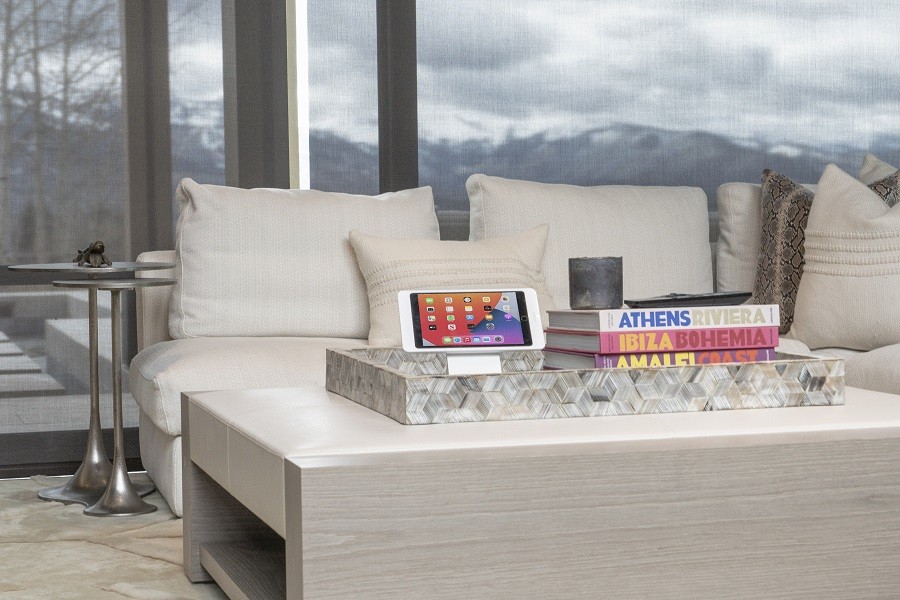 Stylish and sophisticated Control4 smart home touchscreen sits in a modern living room. 