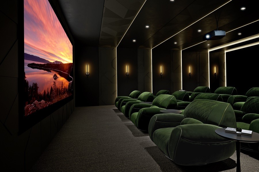 A sophisticated and modern custom home theater with plush green chairs, accenting lights, and a large bright screen upfront. 